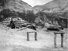 volcanic ash surrounds log cabins in a valley