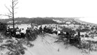 historical photo of a group of people sitting on a hill