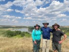 three people stand in a field