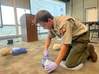 a man practices CPR on a mannequin
