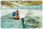 a person crouching on glacier ice