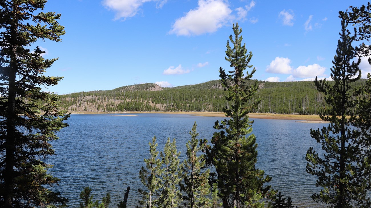 A lake surrounded by rolling hills and forests.