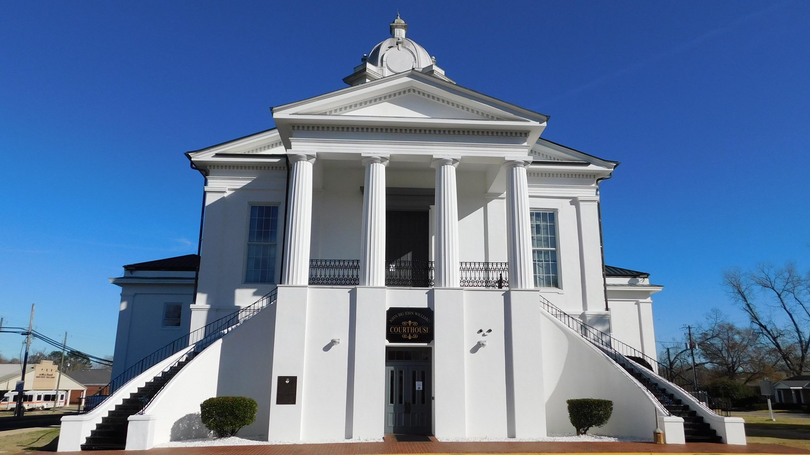 A white Greek Revival-style Courthouse stands tall.