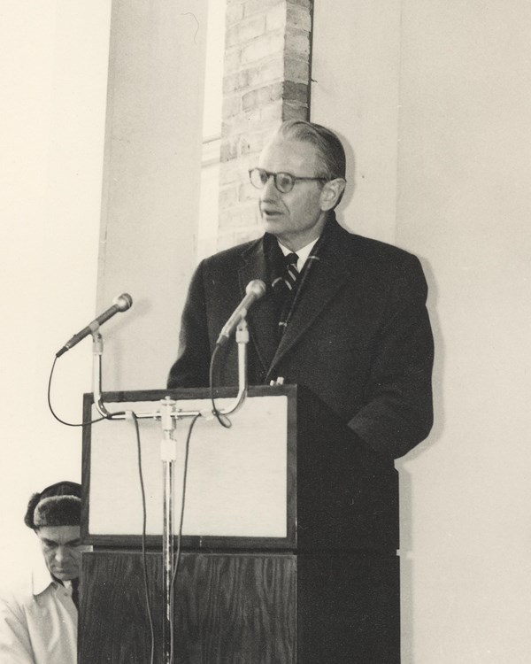 man stands at podium and delivers speech