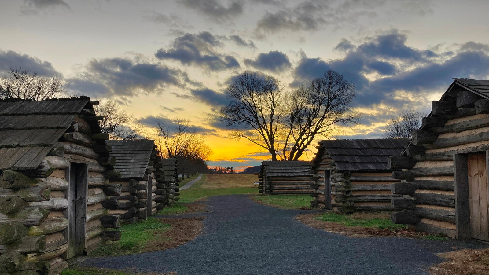 outdoors, log huts, gravel path, sunset, clouds, trees