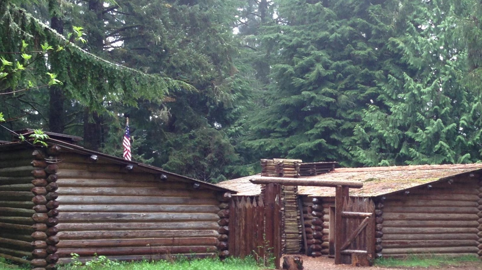 Small 50 foot by 50 foot log cabin style fort surrounded by tall evergreen trees.