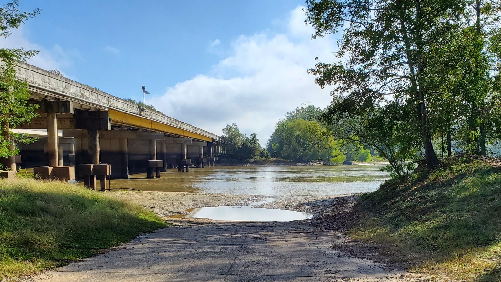 long driveway down to the river with a highway bridge in the distance