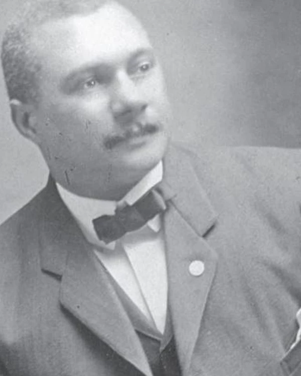 A photo of an African American man, Harry, leaning to the left, with a bowtie. Formal photo.