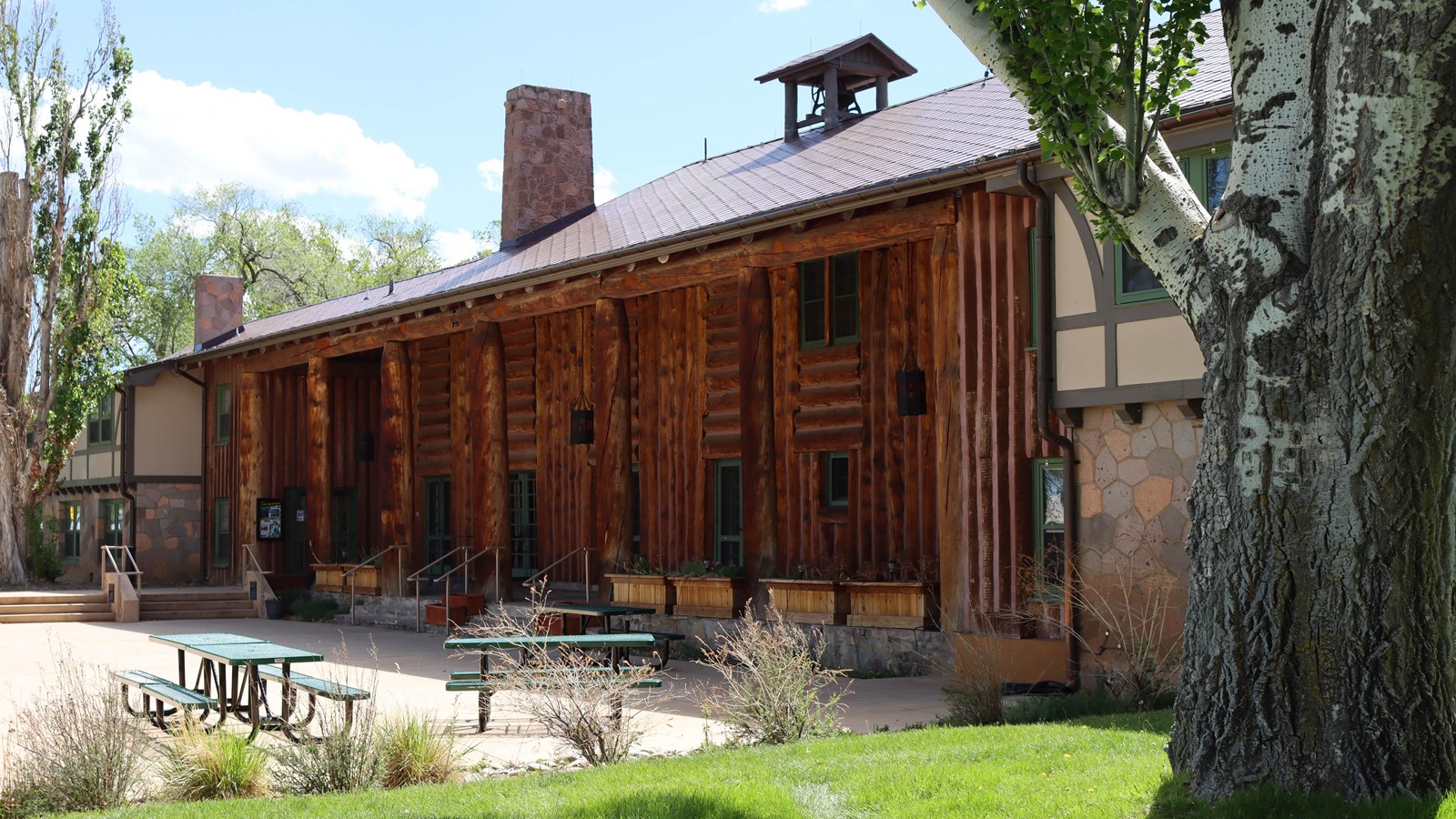 A large log structure with picnic area in front