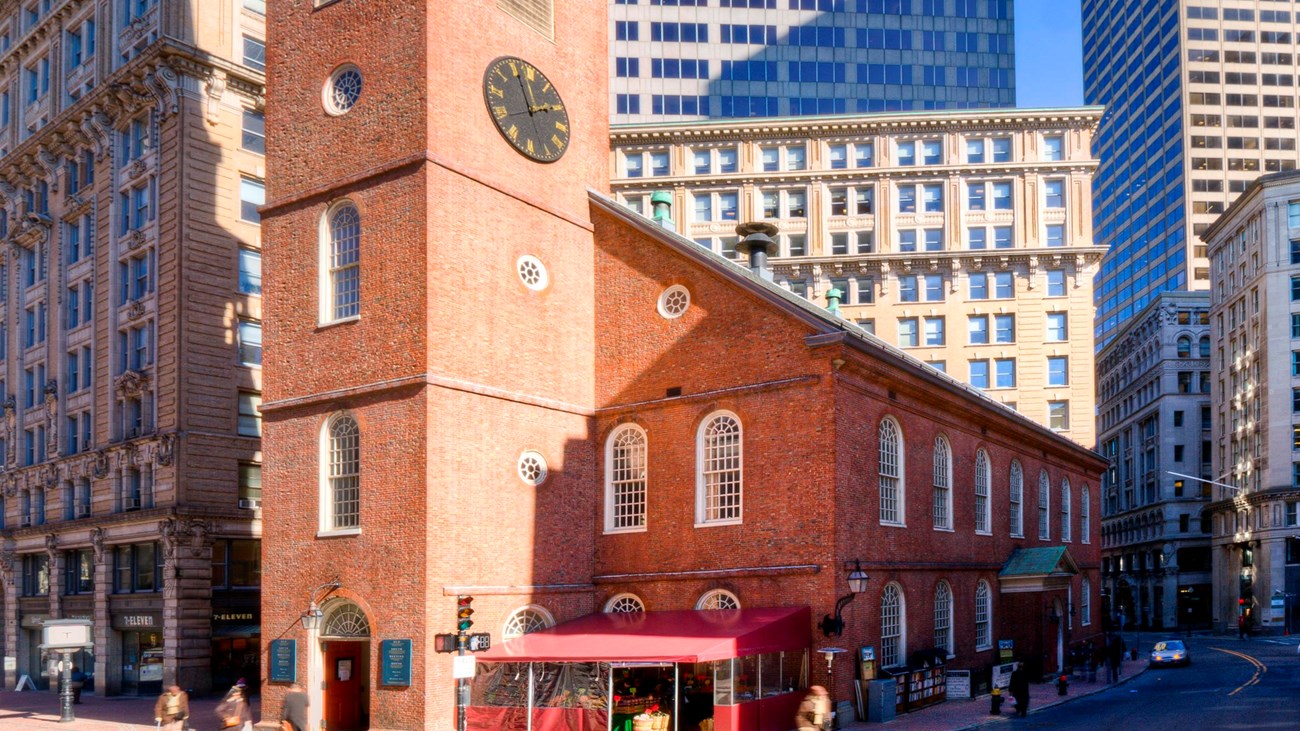 Brick two story building with a brick steeple in the center-front of the building.