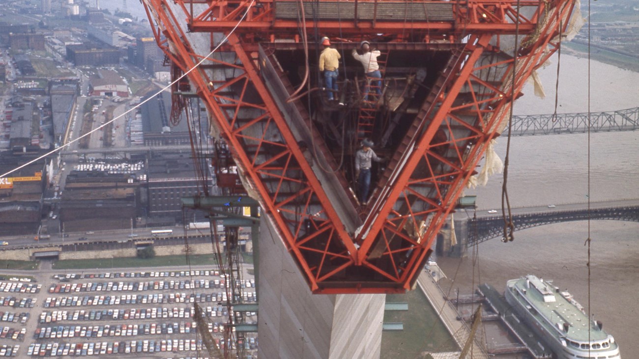 looking into one of the triangle shaped pieces of the Arch from high up, cars and river below