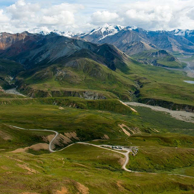 Grassy foothills leading to mountain peaks