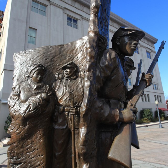 Memorial sculpture and wall of servicemen names.