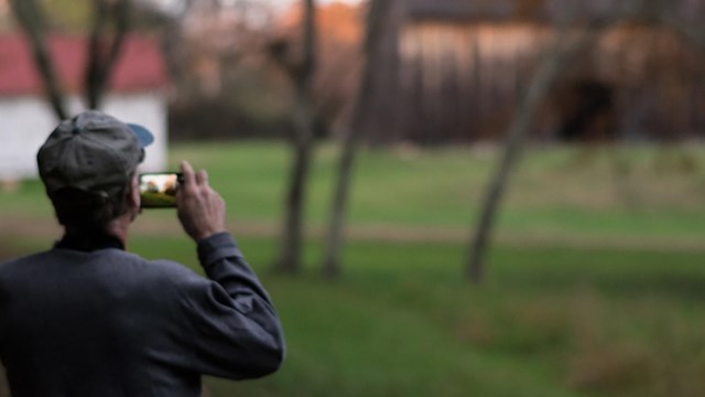 Man views landscape through his smartphone