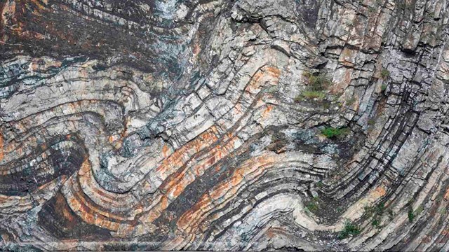 A rock wall showing folds of different strata.