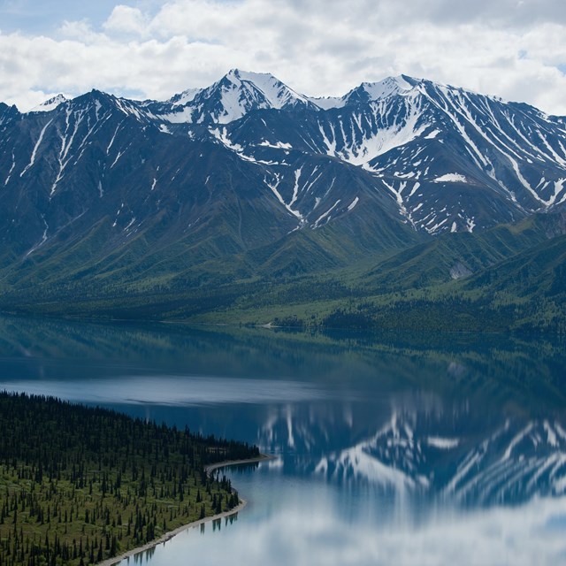 snow-capped mountains reflected in a glassy lake