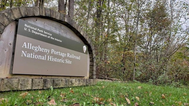 Park entrance sign with leaves.