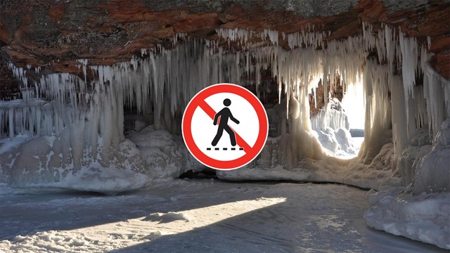Photograph inside a sandstone cave covered in ice with sunlight streaming in through an opening.