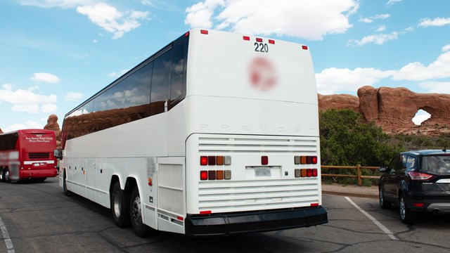 A large white bus in a parking area.