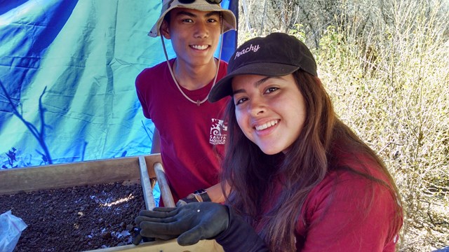 Two students sift for artifacts.