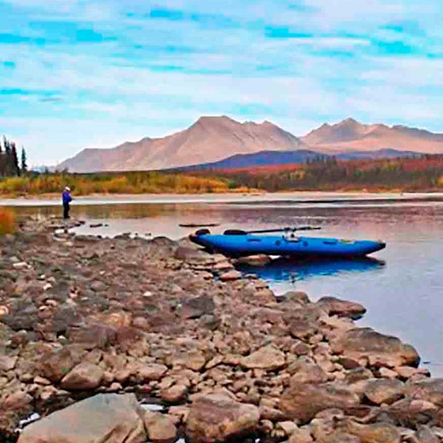 A pack raft pulls up to the shore in the Brooks Range.