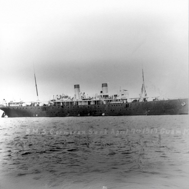 A large ship with two smokestacks and two masts.