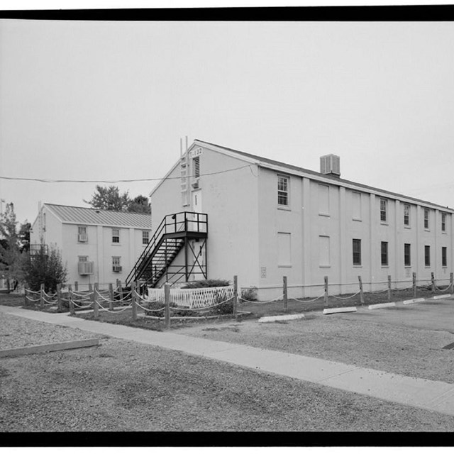 Two two-story buildings surrounded by lawns and fence