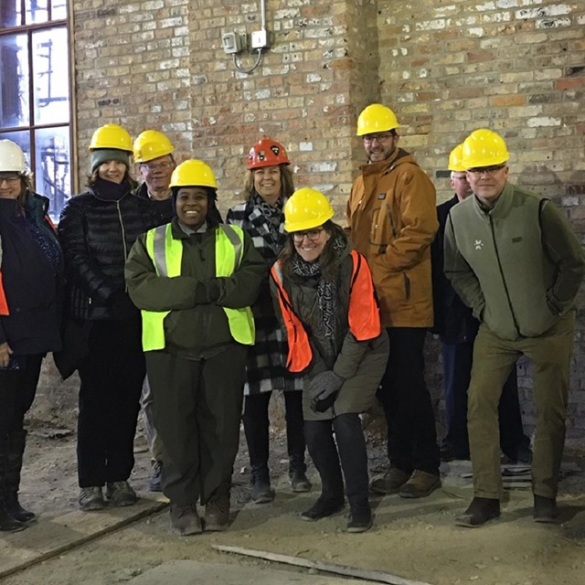 A group of people wearing yellow hard hats