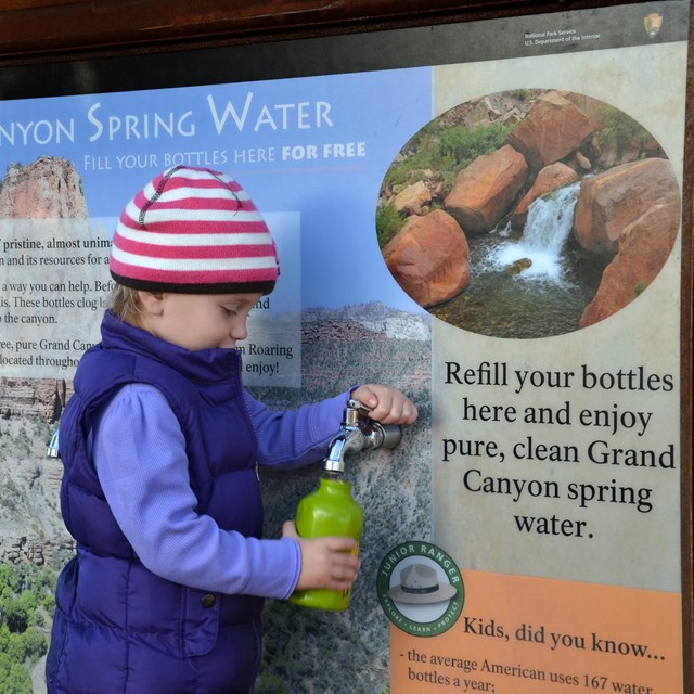Kid filling up a water bottle