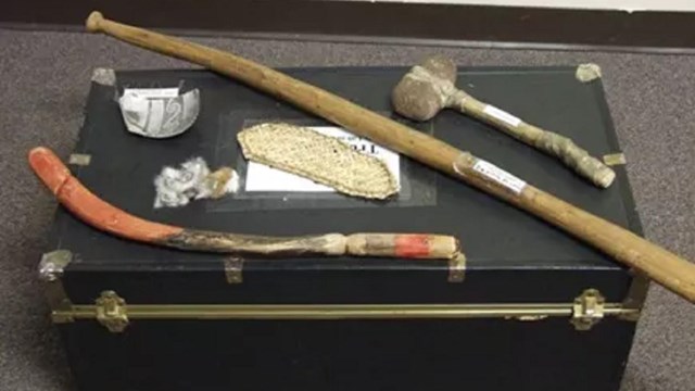 A view of a closed travel trunk from above with replica artifacts displayed on top.