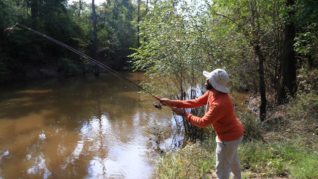 a man fishing by a river