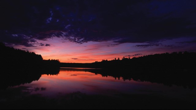 Sunset of a river with trees in the background