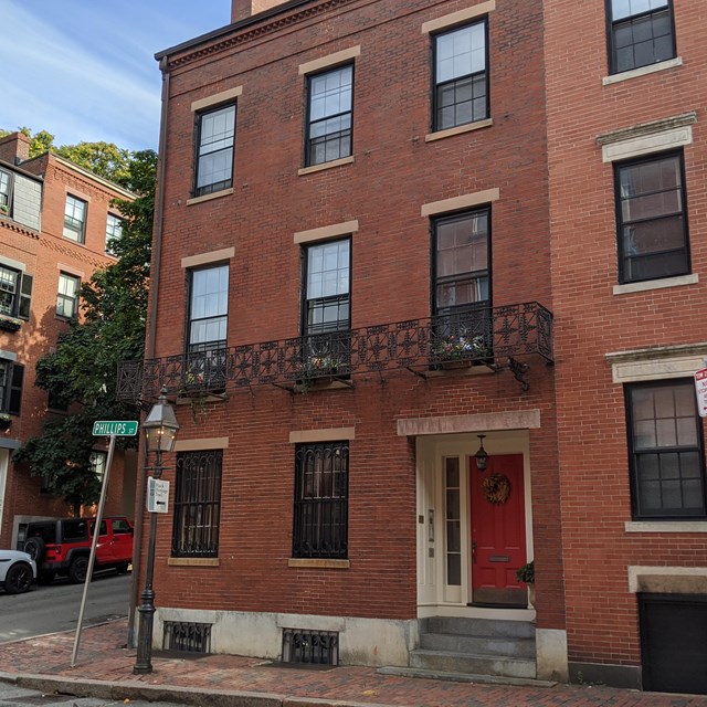 three story brick townhouse on a street corner.