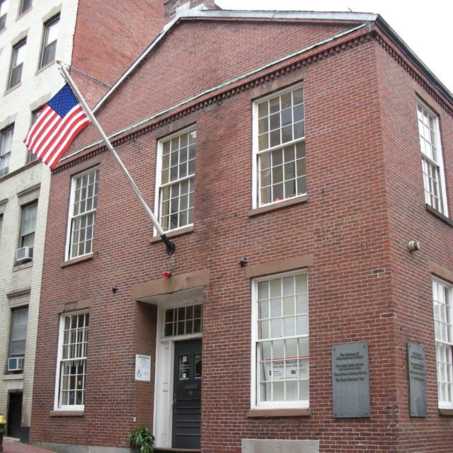 two story brick school house on a street corner.