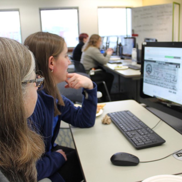 Two women work to transcribe a document from the Library of Congress 