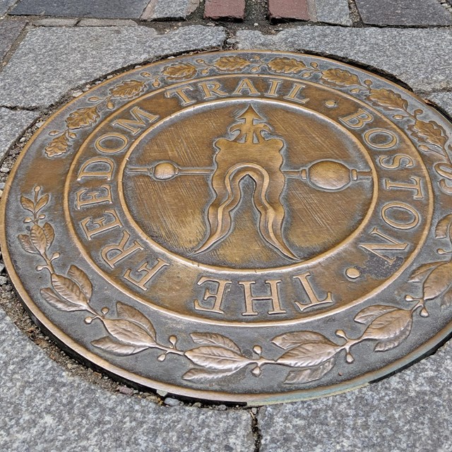 A circular bronze plaque reading 