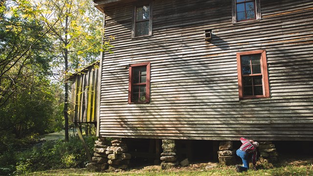 A man inspects the exterior of Boxley Grist Mill.