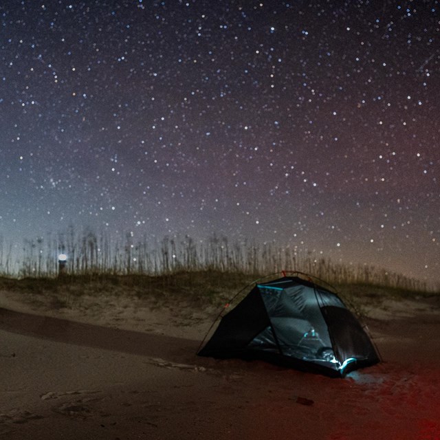 One tent on the beach at night. 