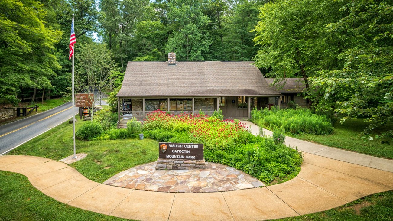 Stone and wood structure with park sign in front.