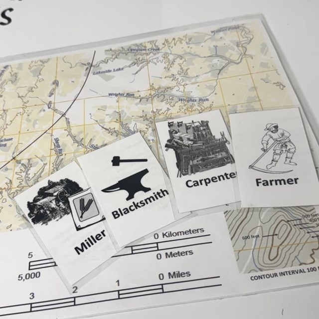 Map with18th century career images laying overtop a whiteboard reading: 