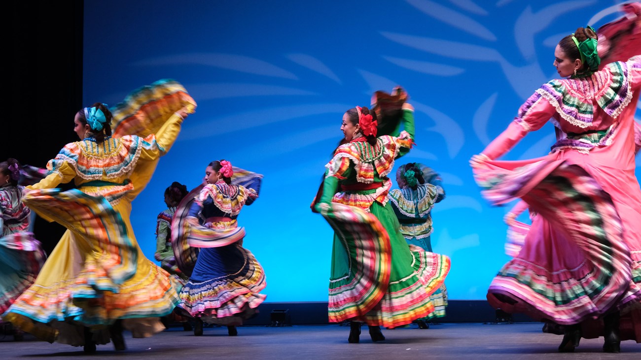 Folklorico dancers in brightly colored dresses perform on stage at Chamizal National Memorial