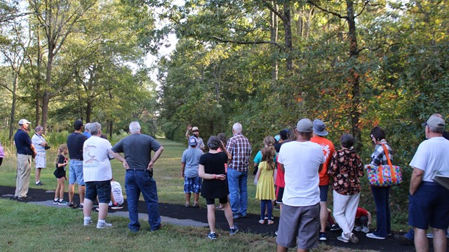 Park ranger leads speaks to a large group of visitors 