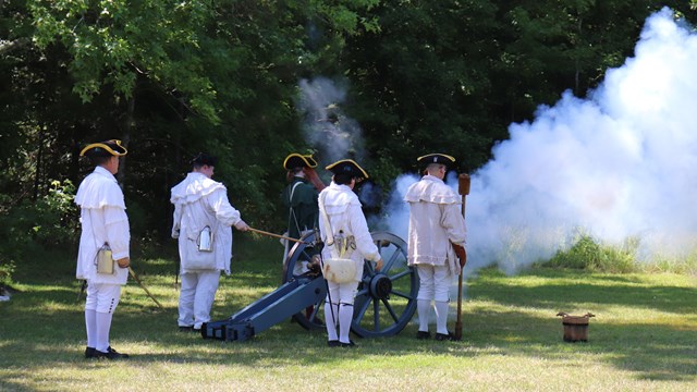 Ranger lead visitors on paved path into woods