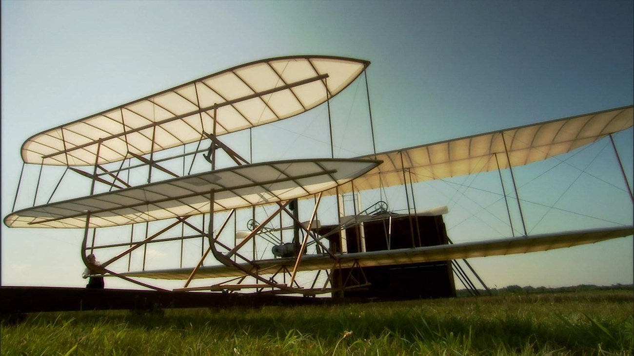 An image of the Wright brothers getting their flyer out of the hangar