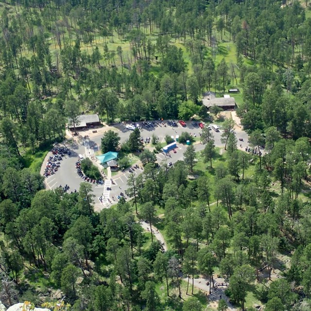 aerial view of visitor center parking lot with cars and people