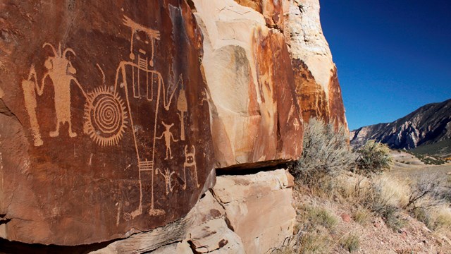 Orange colored rock with Native American designs chiseled into rock