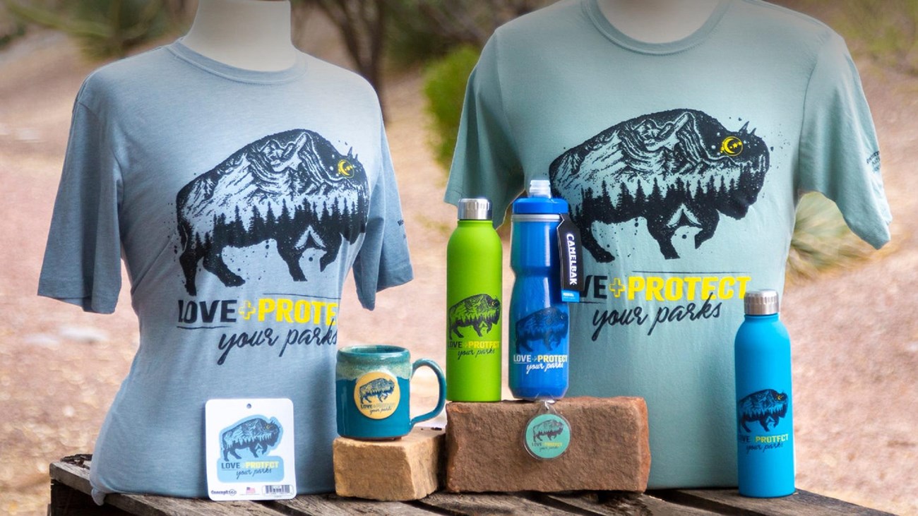 A group of t-shirts with a mug and bottles on a table