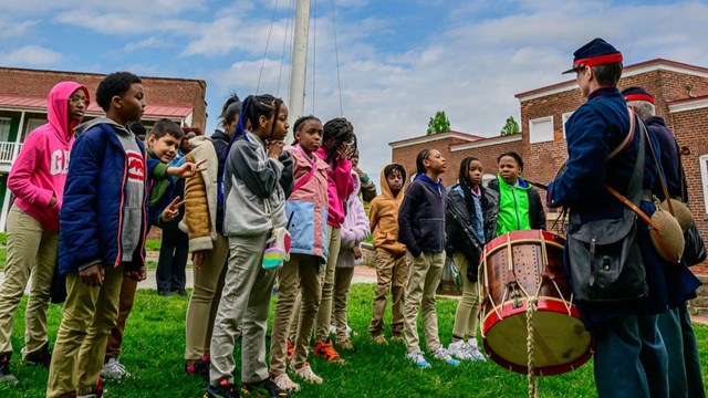 Students observing a fife and drum presentation