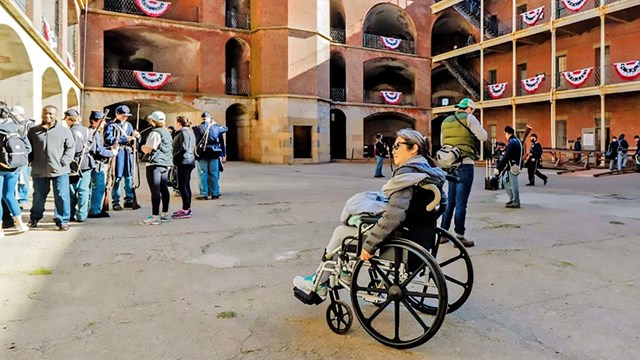 Person in wheelchair enjoying Fort Point's promenade.