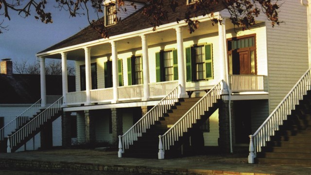 two story building with stairs on each side viewed from an angle